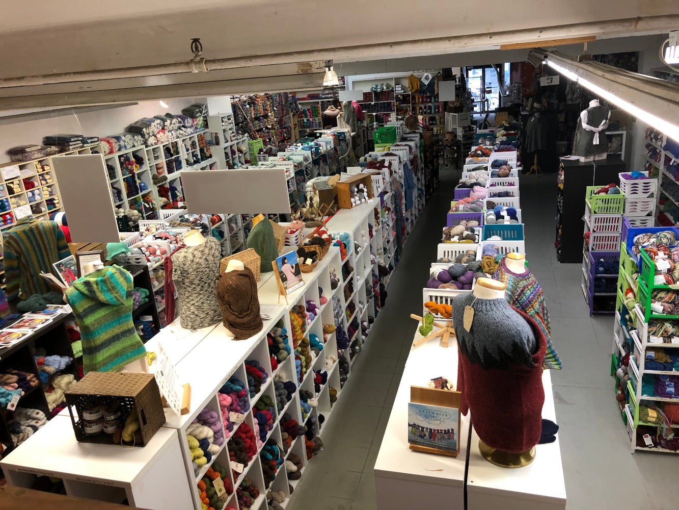 Photograph  of the interior of the 658 Queen Street West location of Romni  Wools, viewed from above.