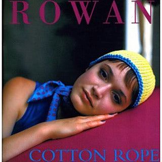 The cover of the collection with a reposed model wearing a knitted blue and yellow hat
