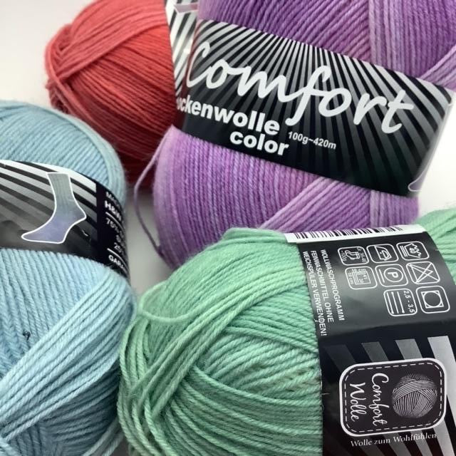 A close up of four balls of colourful sock yarn