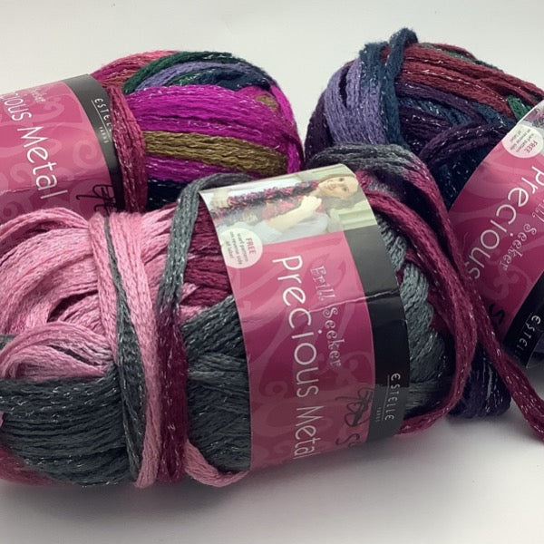 A group image of three multi colour balls of scarf yarn